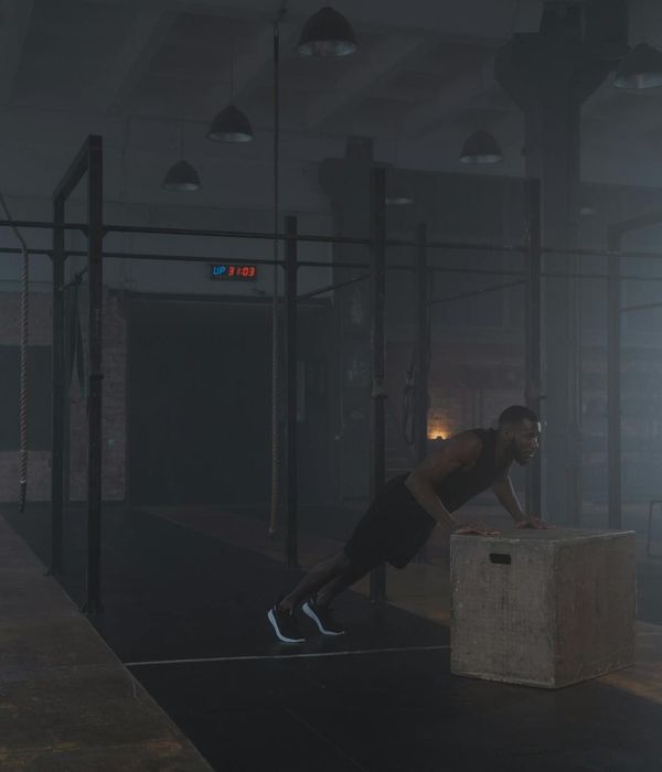 Strong man performing functional exercises in a modern training space.